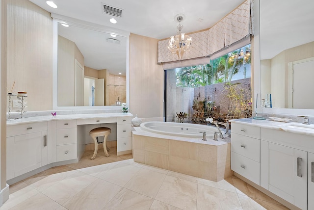 full bathroom featuring tile patterned floors, an inviting chandelier, vanity, a garden tub, and a stall shower