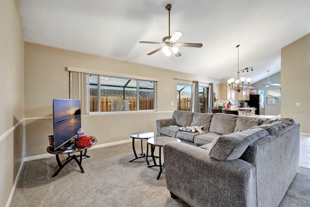 living room with ceiling fan with notable chandelier, light carpet, and vaulted ceiling