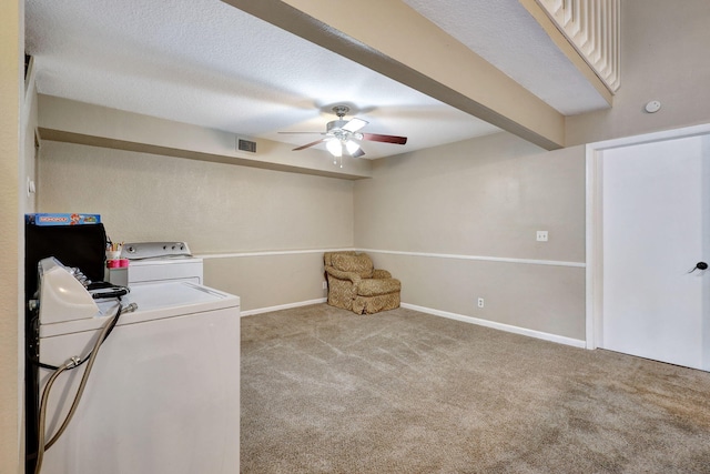 laundry room with a textured ceiling, light carpet, ceiling fan, and washing machine and clothes dryer