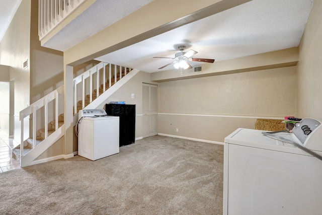 laundry room featuring ceiling fan, washer and dryer, a textured ceiling, and light carpet