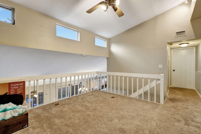 interior space featuring carpet, ceiling fan, and vaulted ceiling