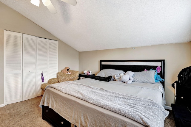 carpeted bedroom featuring a closet, vaulted ceiling, ceiling fan, and a textured ceiling