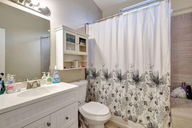 bathroom with toilet, vanity, tile patterned flooring, and curtained shower