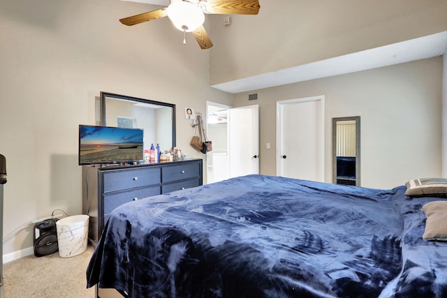 carpeted bedroom with a high ceiling and ceiling fan