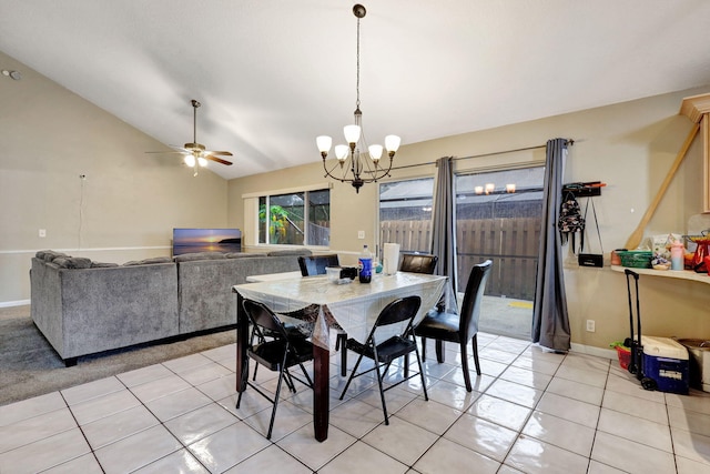 dining space featuring ceiling fan with notable chandelier, light tile patterned floors, and vaulted ceiling