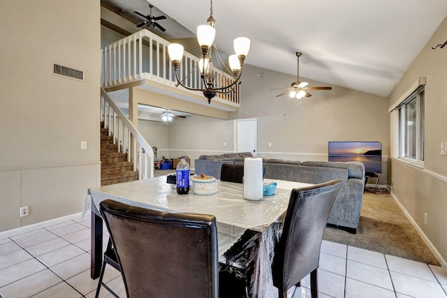 tiled dining area featuring high vaulted ceiling and an inviting chandelier