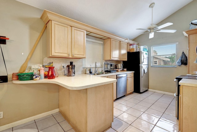 kitchen featuring kitchen peninsula, lofted ceiling, light tile patterned flooring, and stainless steel appliances