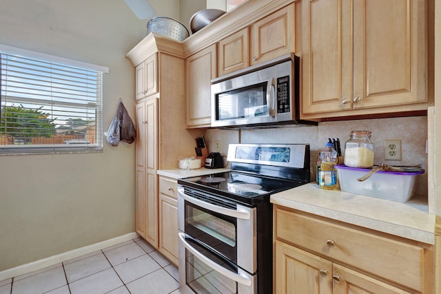 kitchen featuring light brown cabinets, light tile patterned floors, appliances with stainless steel finishes, and tasteful backsplash