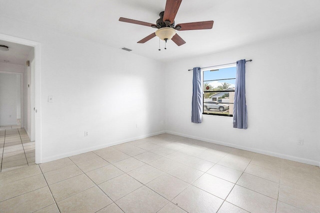 empty room with ceiling fan and light tile patterned flooring