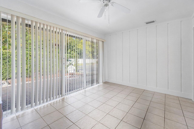 tiled spare room featuring ceiling fan