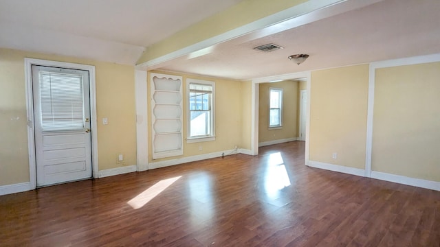 empty room featuring hardwood / wood-style floors and beam ceiling