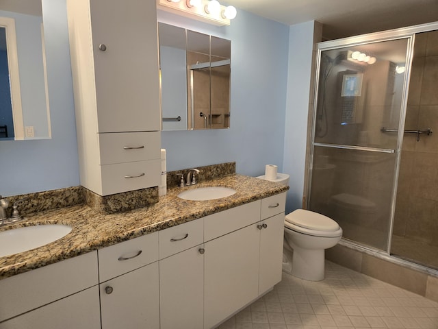 full bathroom with a stall shower, a sink, toilet, and double vanity