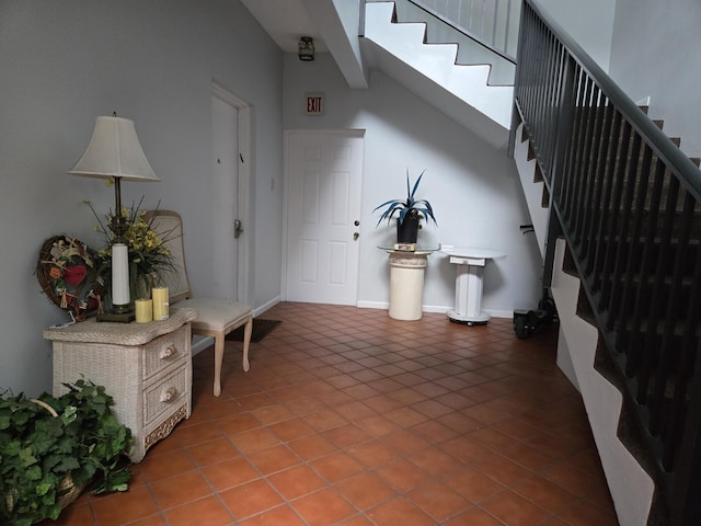 entrance foyer with stairs, baseboards, and tile patterned floors