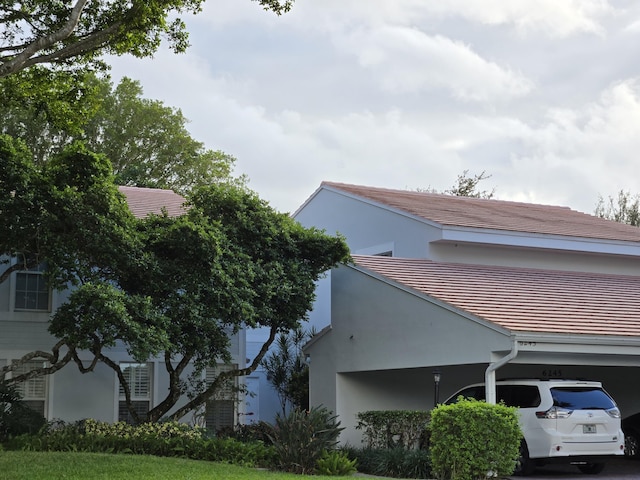 view of side of property with a tiled roof and stucco siding