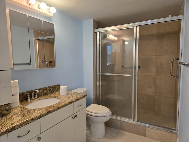 bathroom with toilet, a stall shower, tile patterned floors, and vanity