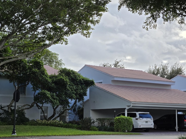 view of side of property featuring a carport and a tile roof