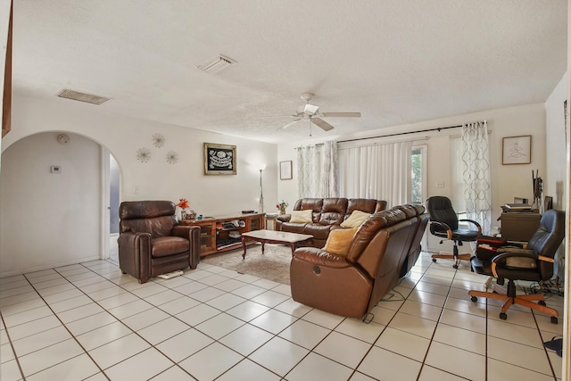 1801 SW Beeker St S, Port Saint Lucie, FL 34953 - living area featuring ceiling fan, arched walkways, a textured ceiling, and light tile patterned flooring