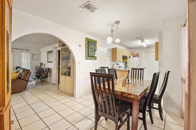 1801 SW Beeker St S, Port Saint Lucie, FL 34953 - dining area with arched walkways, light tile patterned flooring, a chandelier, and a textured ceiling