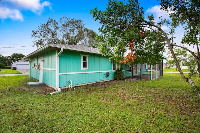 1801 SW Beeker St S, Port Saint Lucie, FL 34953 - view of home's exterior with a yard, a sunroom, a detached garage, and roof with shingles