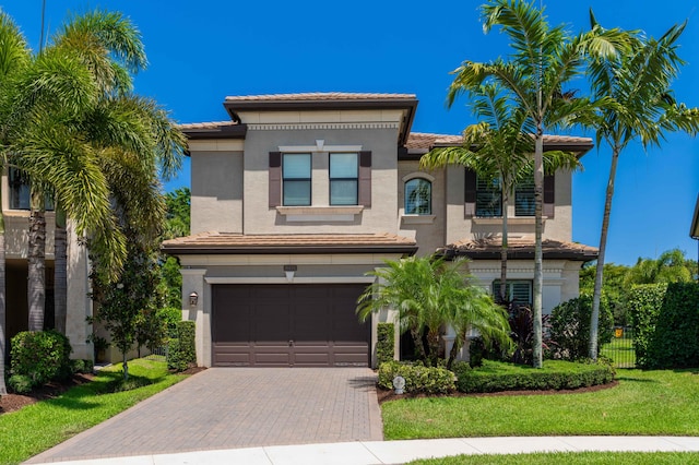 mediterranean / spanish house with a front yard and a garage