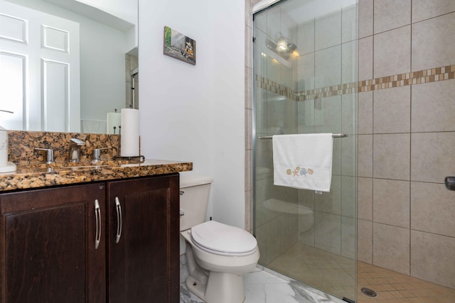 bathroom featuring vanity, an enclosed shower, and toilet