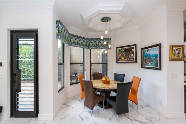 dining area with ornamental molding and a tray ceiling