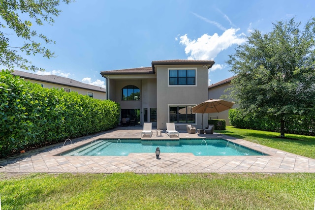 view of swimming pool featuring pool water feature, a patio, and a lawn