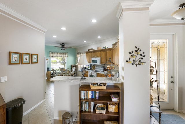 kitchen with ceiling fan, kitchen peninsula, white appliances, a kitchen bar, and light tile patterned floors