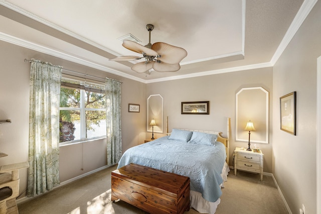 bedroom featuring ceiling fan, ornamental molding, light carpet, and a tray ceiling