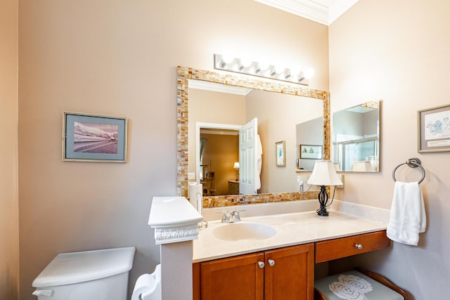 bathroom featuring vanity, toilet, and crown molding