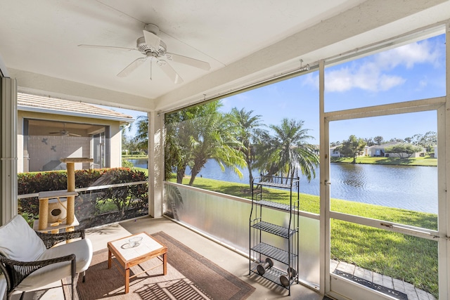 sunroom with a water view and ceiling fan