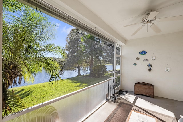 sunroom with a water view and ceiling fan