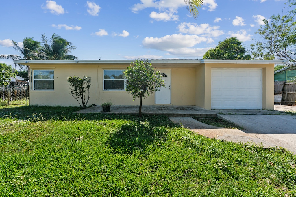 ranch-style home with a front lawn and a garage