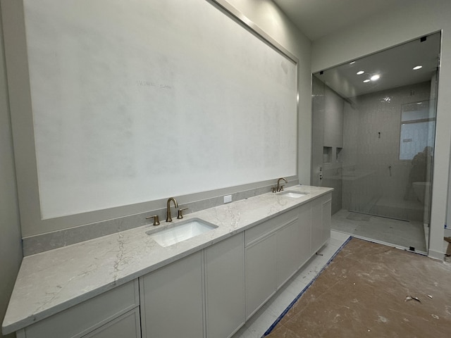 bathroom with a tile shower and vanity