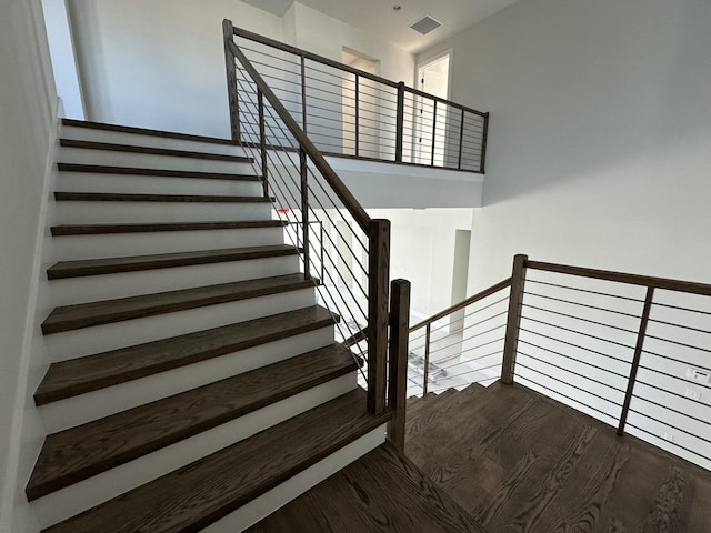 stairs with visible vents and wood finished floors