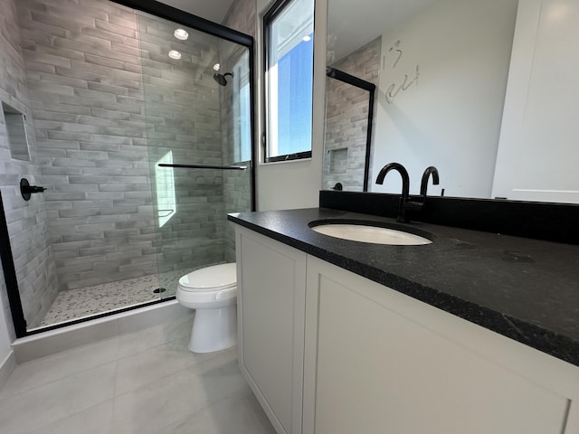 bathroom with tile patterned floors, a shower stall, toilet, and vanity