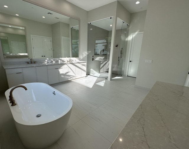 full bath with a stall shower, a soaking tub, vanity, and recessed lighting