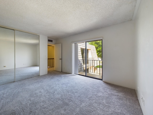 spare room featuring carpet floors and a textured ceiling