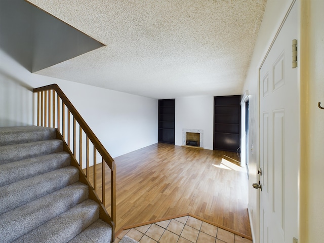 staircase featuring hardwood / wood-style floors and a textured ceiling