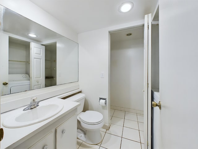 bathroom featuring toilet, vanity, tile patterned floors, and washer / dryer