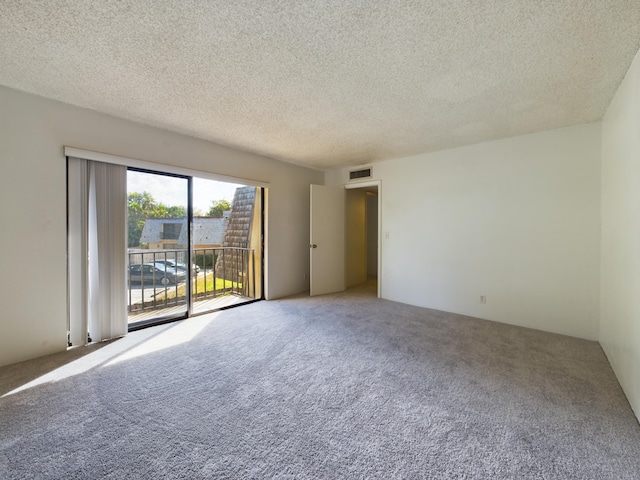 carpeted spare room with a textured ceiling