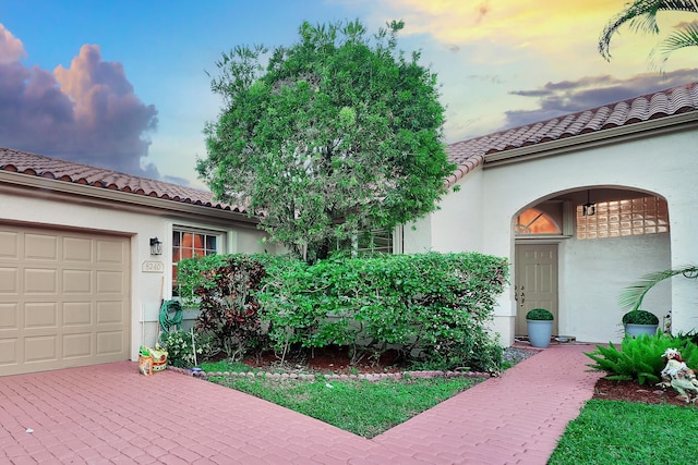 exterior entry at dusk with a garage