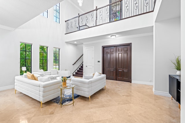 living room with ornamental molding and a towering ceiling