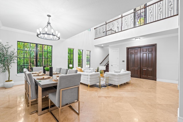 dining room with ornamental molding, a towering ceiling, and a chandelier