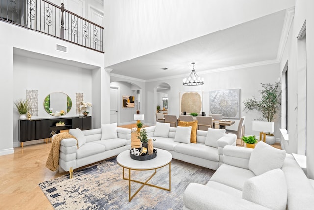 living room with a towering ceiling, a chandelier, crown molding, and light tile patterned floors