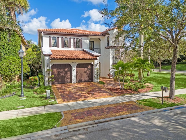 mediterranean / spanish-style home featuring a garage, a front yard, and a balcony