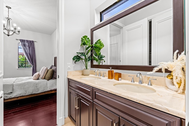 bathroom with vanity, hardwood / wood-style floors, and a notable chandelier