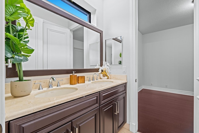 bathroom featuring vanity, hardwood / wood-style floors, and a textured ceiling