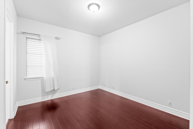 spare room with a textured ceiling and hardwood / wood-style flooring