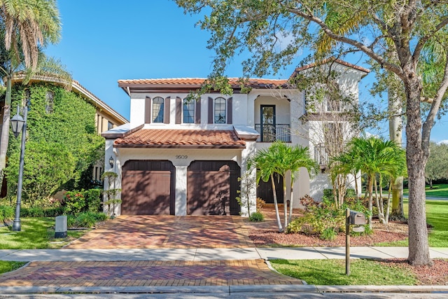 mediterranean / spanish home featuring a balcony and a garage